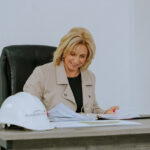 Woman reviewing paperwork at a Pickstock Homes desk.