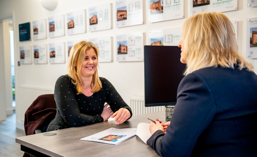 Two people reviewing home details at a table.