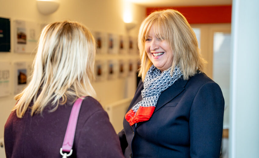 Two people discussing property brochures