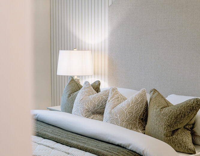 New build bedroom with striped bedding and window light.