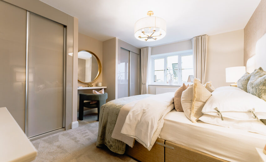 New build bedroom with upholstered headboard and bedside lamps.