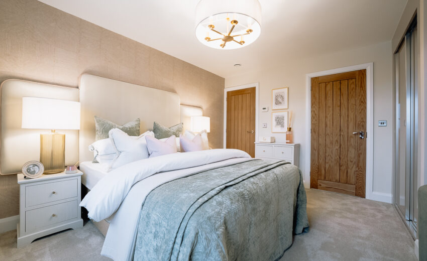 New build bedroom with bed and pendant light.