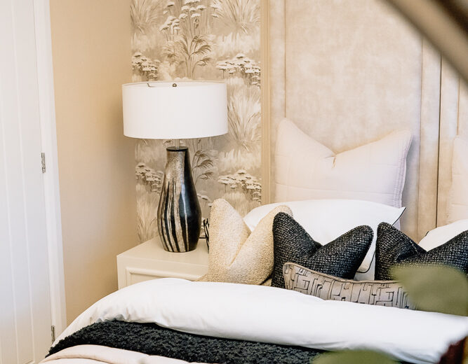 New build bedroom with mirror reflection and bedside lamp.