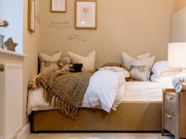 New build bedroom with neutral bedding and pendant light.