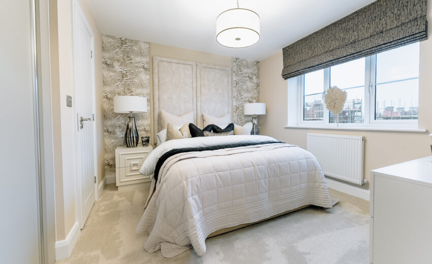 New build bedroom with upholstered bed and pendant light.