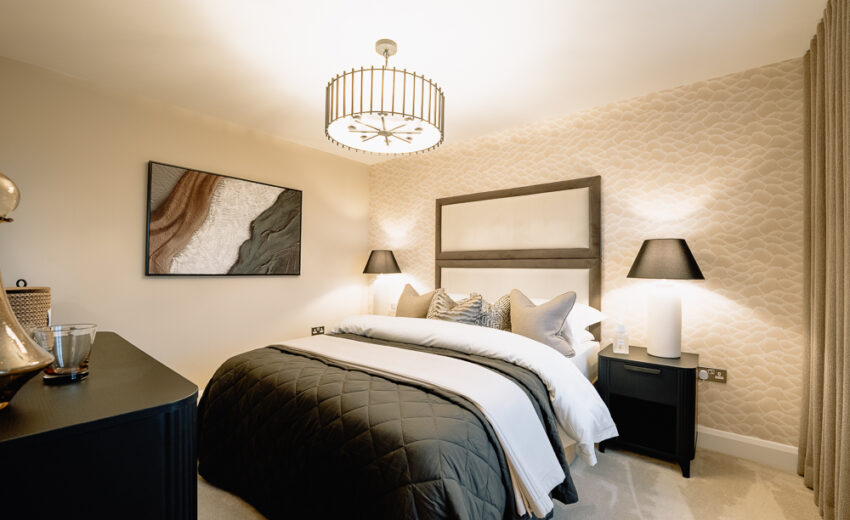 New build bedroom with arched headboard and bedside lamps.