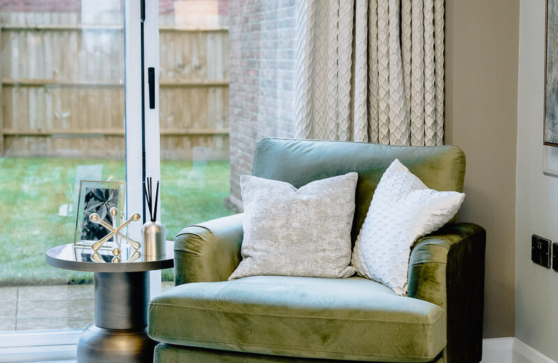 New build green accent chair by the window.