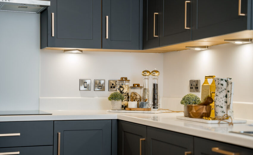 New build kitchen with dark cabinetry and integrated lighting.