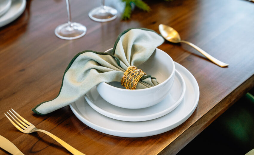 New build dining table setting with crockery and napkin.