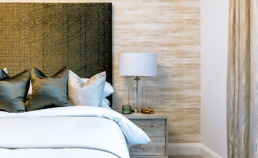Bedroom corner with neutral bedding in a new build.