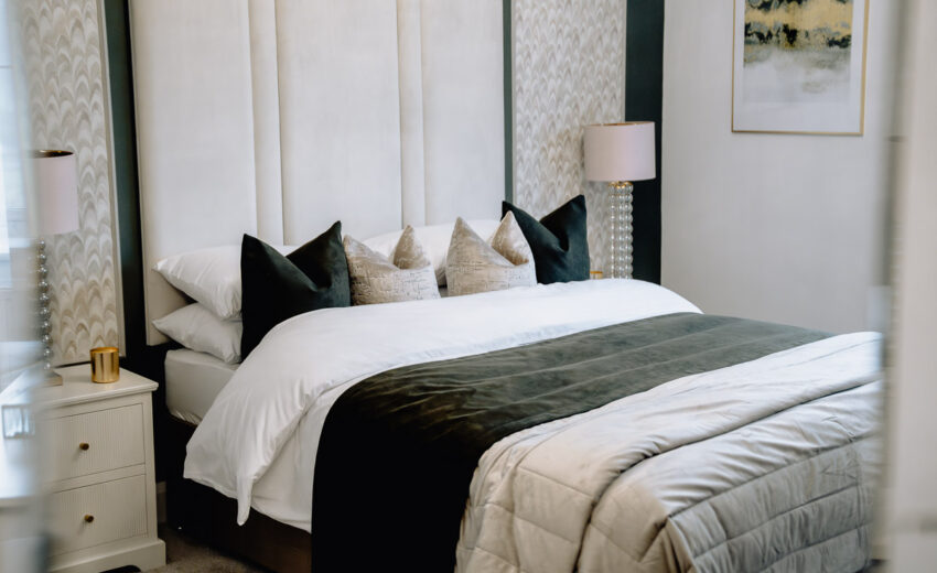 New build bedroom with upholstered headboard and neutral bedding.