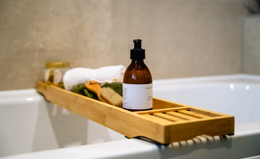 The Tweed new build bath tray with toiletries.