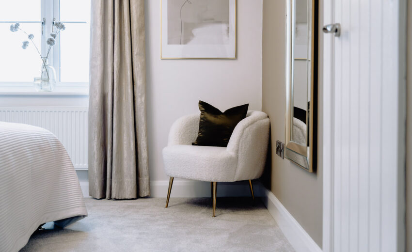 New build bedroom with accent chair and dressing area.